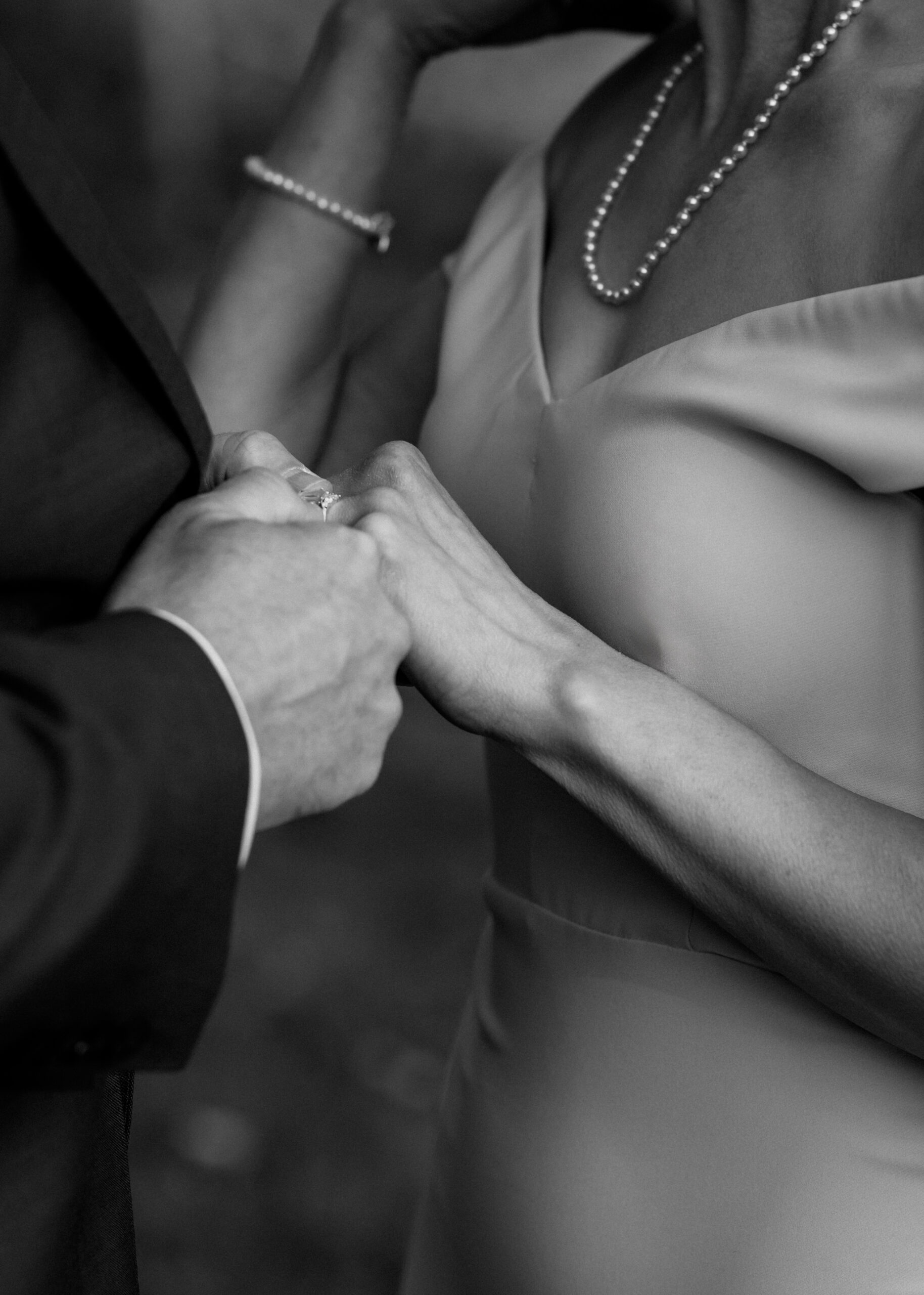 a close up of a man and woman's hands. they are exchanging wedding rings. 